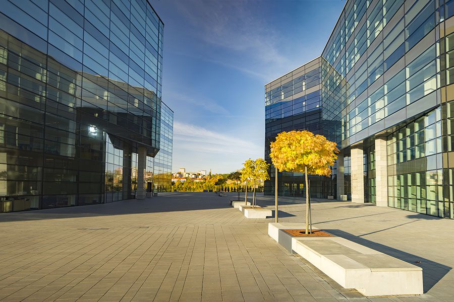 Insurance Quote - View of Two Commercial Office Buildings Next to a Paved Walkway in the City at Sunset